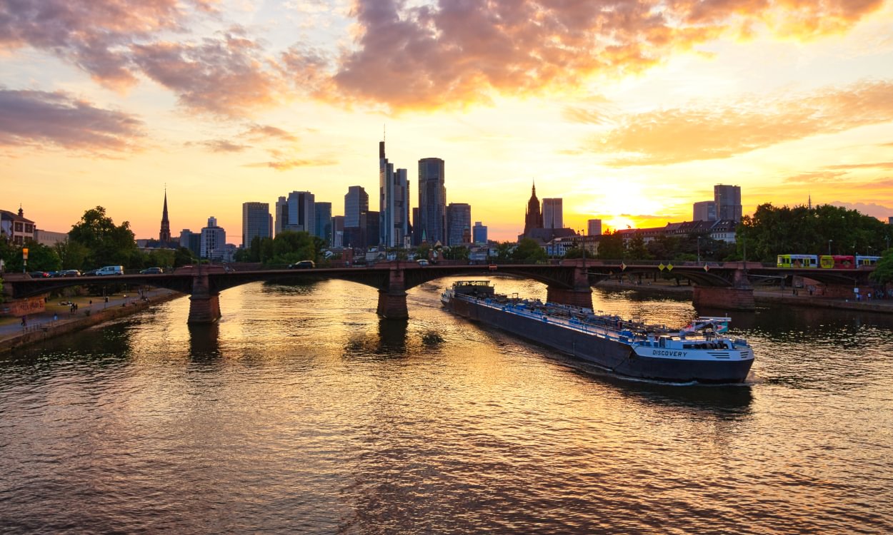 Hochhaussilhouette und Ignatz-Bubis-Brücke im Abendrot von der Flößerbrücke gesehen, 2025.